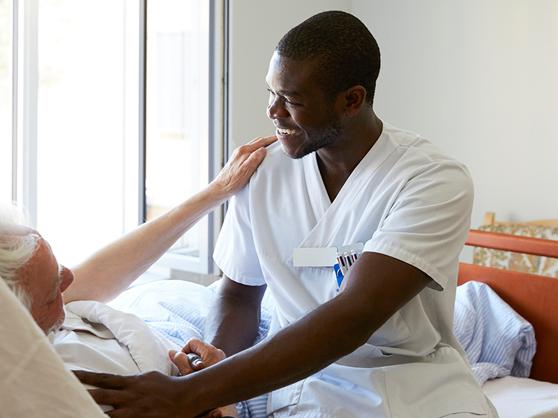 Tulane nurse comforting a patient in the hospital