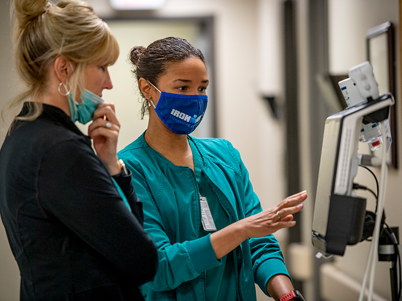 Tulane nurses consulting over a machine